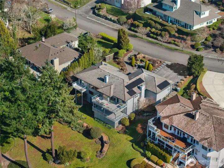 Rear elevation showcases multiple decks, manicured grounds, and expansive outdoor living.