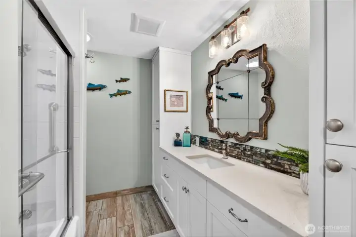 The hallway bath serves bedroom 2 and 3 with custom tile work and a glass tub enclosure.