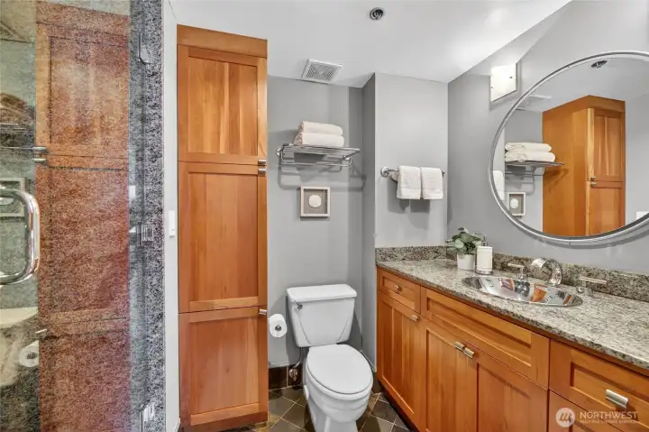Beautiful bathroom with granite counters, slate floors, ceiling to floor stone shower with glass door, maple cabinets and designer fixtures.