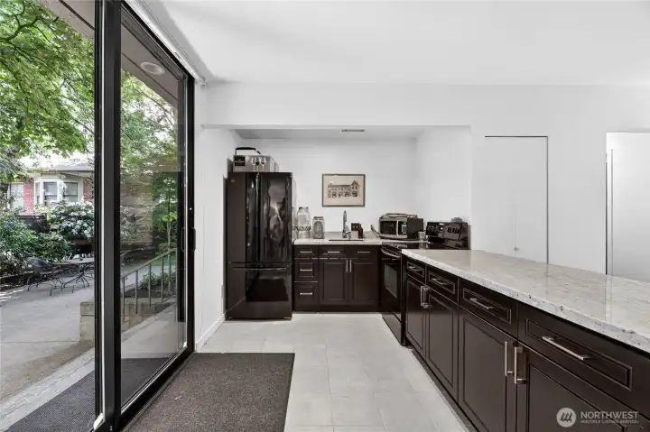 Community lounge  with kitchen space, restroom and sliding glass doors that leads to spacious patio area for barbecuing cooking space.