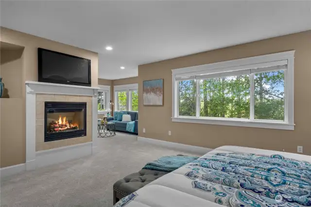 Unwind in the primary bedroom, complete with a cozy fireplace and a tranquil space perfect for reading or simply relaxing.