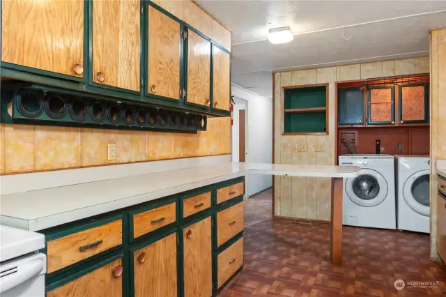 Spacious galley kitchen, nice washer/driver, and down the hallway in the background are three bedrooms.