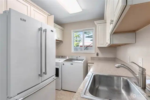 The mud room/utility room has plenty of workspace and storage and a second refrigerator