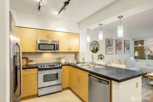The kitchen features black quartz counters, maple cabinets, and a stainless GE appliance suite.