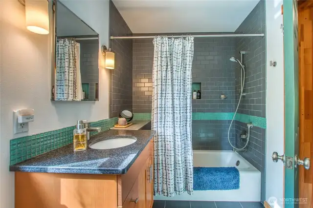 The vanity tile connects to the contemporary bath surround.