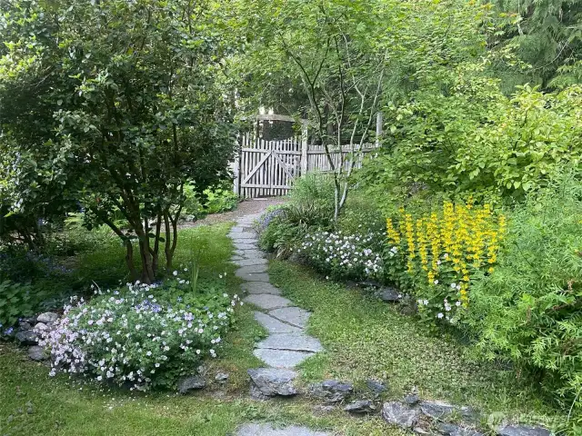 An entry path meanders through the gate that keeps the garden safe from deer.