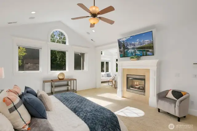 Primary suite with vaulted ceilings, cozy gas fireplace, and large sitting area.