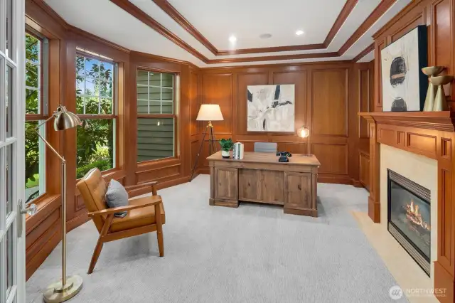 Executive style office with wood panels, double coffered ceiling and crown molding.  Even a cozy gas fireplace for additional warmth and ambience.