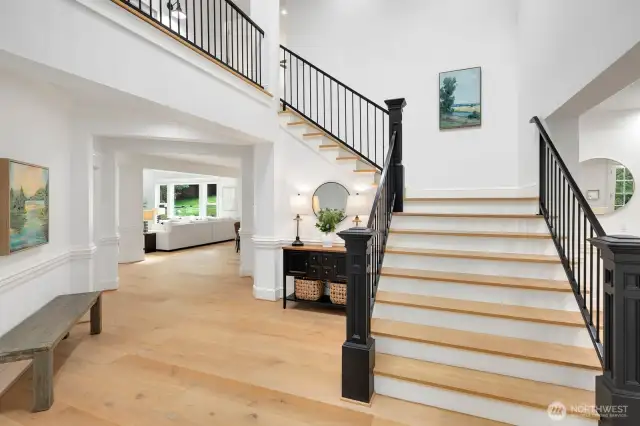 Grand stairway and foyer welcomes you and your guests. Custom railings accent the wood floors.