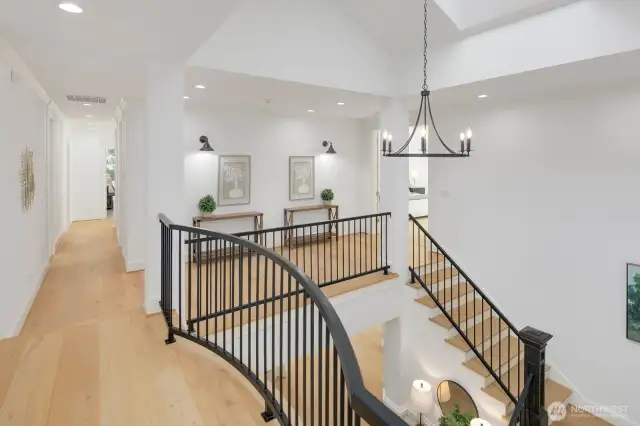 One of two staircases, this front staircase with grand vaulted ceilings and skylights make it light and bright.
