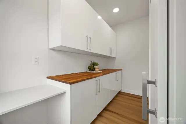 The walk-in pantry has a wood chopping block counter top and a sliding barndoor.