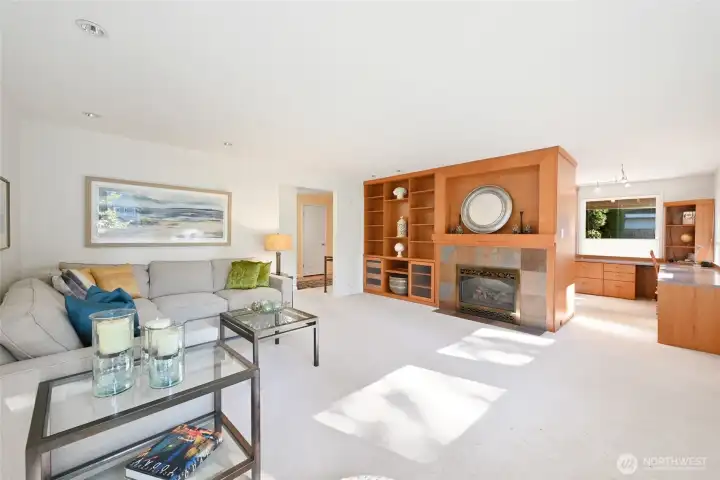 Natural light streaming through wall of windows in formal living room w/gas fireplace.