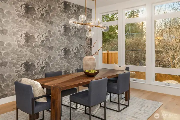 Floor to ceiling window wall perfectly frames dining room with outlooks to mature specimen maple tree and professional landscaping