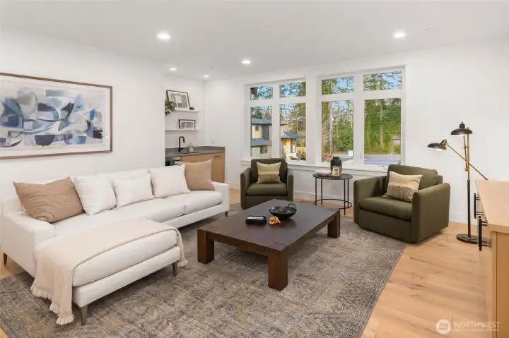Second floor rec room features wide plank hardwood flooring (also included in entire lower level, stairs, upper hallway, and primary bedroom) Built in rift oak cabinets with prep sink and under counter beverage center, and floating rift oak component cabinet