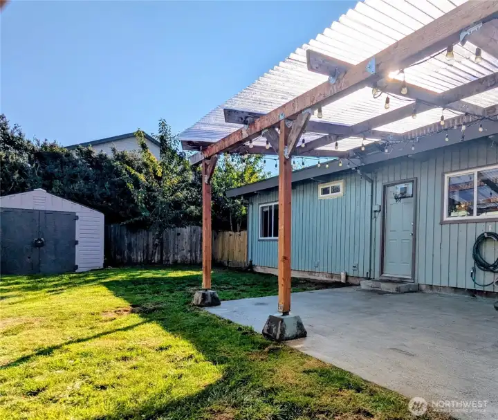 View to storage shed, fenced side yard area, and covered patio