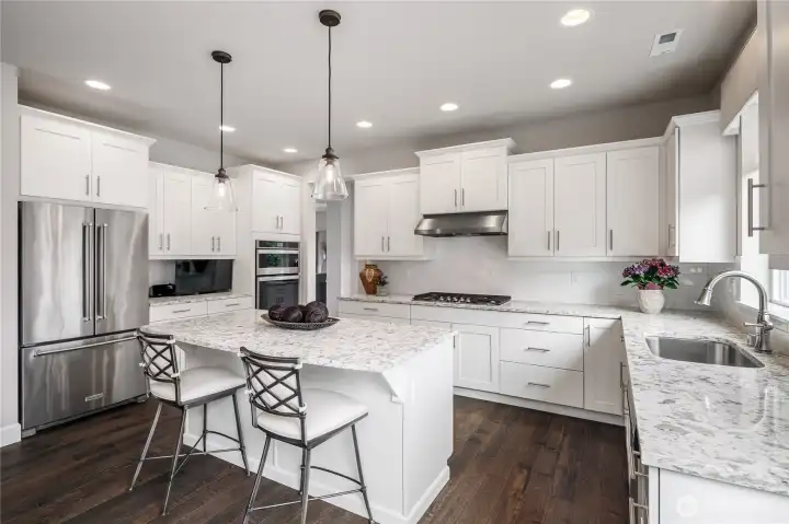 Stainless appliances, white cabinetry and mill work. Undermount sink.