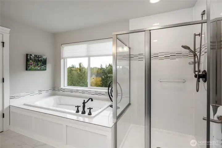 Large soaking tub and shower with custom tile.