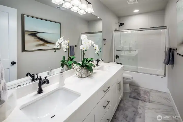 Hall bathroom has quartz counter tops with double undermount sinks and a full tub/shower combo.
