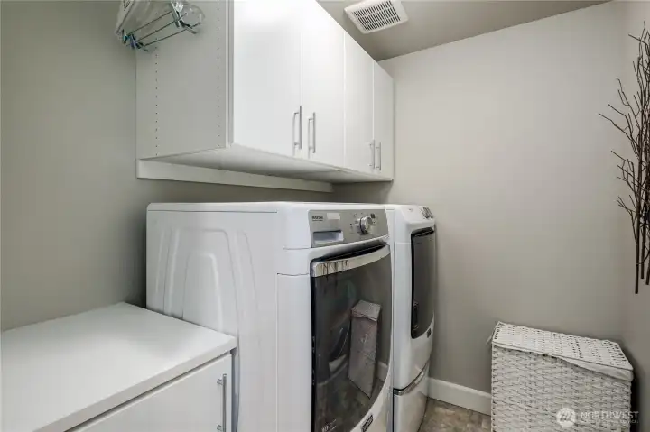 Upstairs laundry room with folding counter and cabinets. Upscale washer & dryer stay with the home.