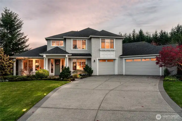Front exterior at dusk. Showcasing long driveway and driveway lights.