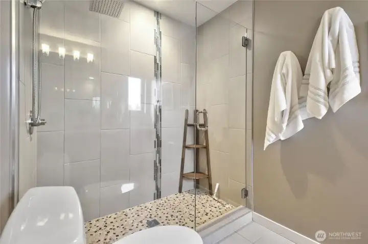Enjoy taking a shower in this oversized shower with gorgeous stone tiles.