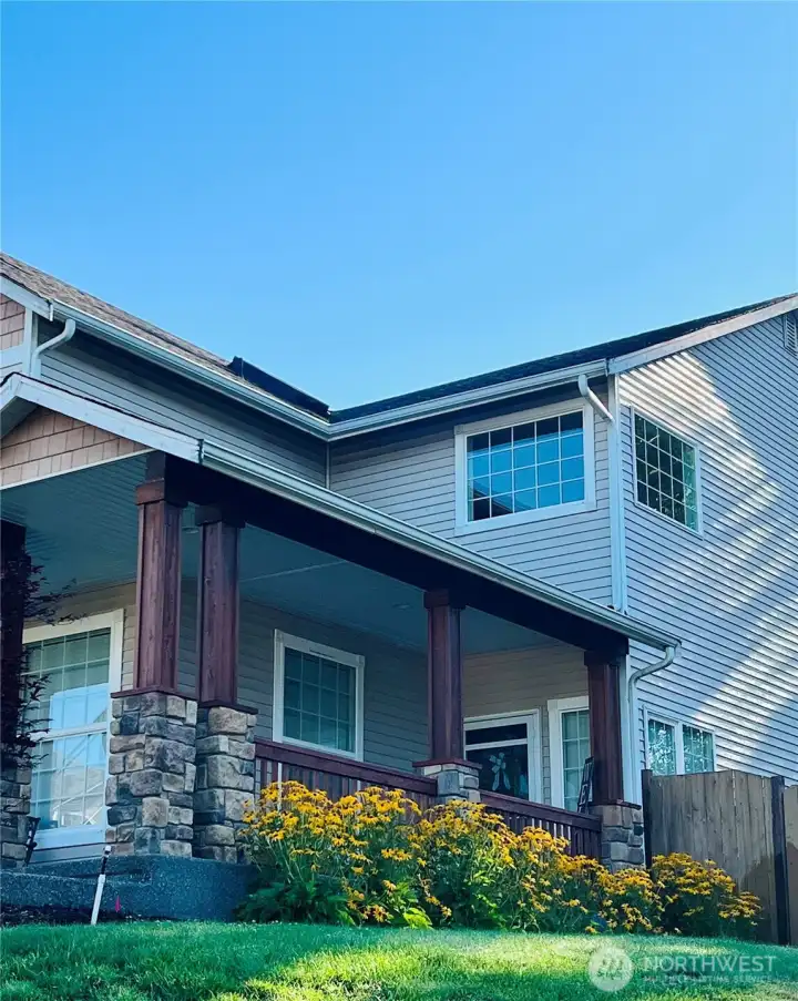 The delightful front corner porch sets the tone—perfect for slow mornings with coffee, evening chats, and that charming small-town welcome.