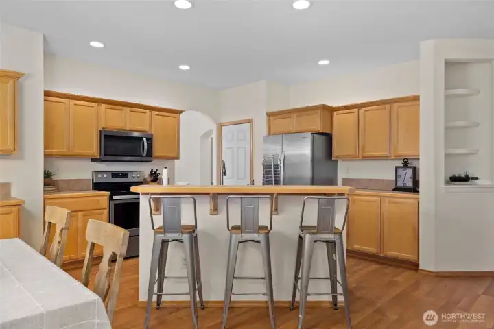 Casual bar seating invites morning pancakes, after-school homework, and late-night chats over a glass of wine.