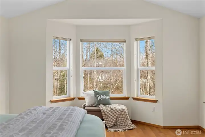 A charming bay window nook offers the perfect spot for morning journaling, quiet reflection, or simply soaking in the peaceful views.