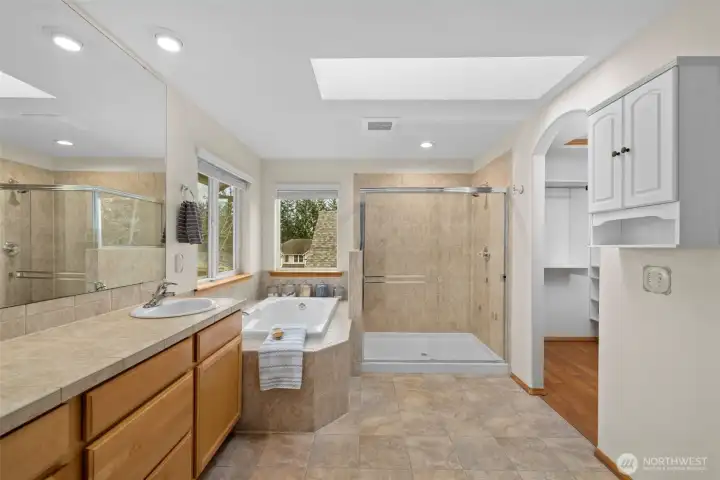 An expansive ensuite bath featuring dual vanities, a soaking tub, and a walk-in shower for a spa-inspired daily routine.