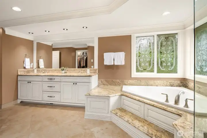 Spacious primary suite ~ serene views of the greenbelt. Large, lavish, spa-inspired en-suite bath with frame-less glass door dual head shower, heated Travertine tile floors, soaking tub, and large walk-in closet.