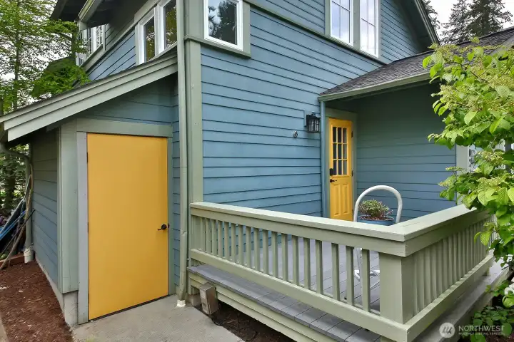 Front porch is screened from the street by mature plantings.