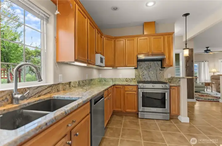 Bright, functional kitchen with warm wood cabinetry, generous counter space, and a large window over the sink—perfect for enjoying the views while doing the dishes.