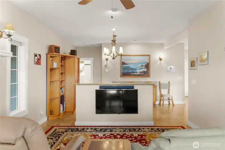 Open living and dining areas connected by a custom blue pine accent shelf, creating separation while maintaining a bright, cohesive flow