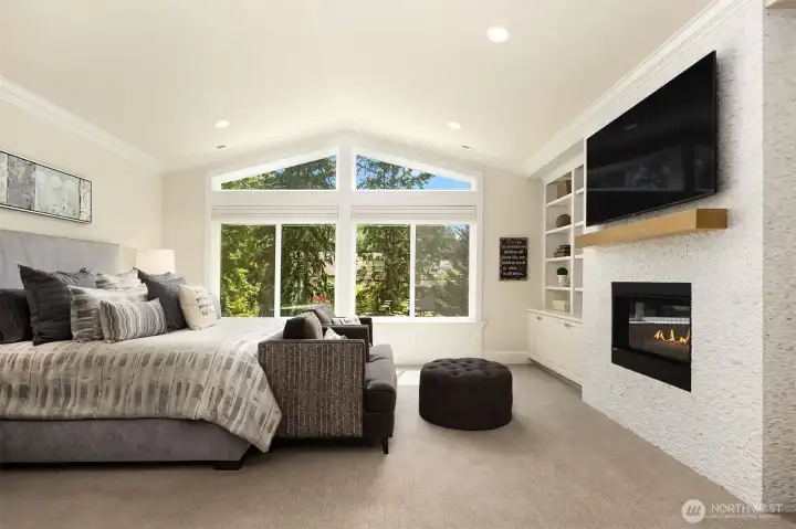 Upstairs, your vaulted primary suite offers its own fireplace and custom library shelving.