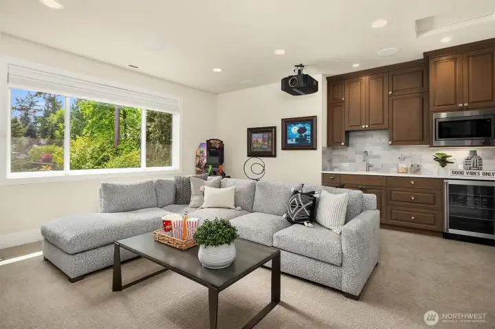 Media room with wet bar, in-ceiling speakers, & XL media screen for epic entertainment.
