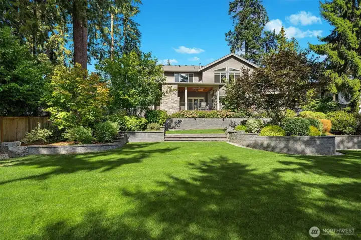 Graceful retaining walls & manicured garden borders lend a park-like feel.
