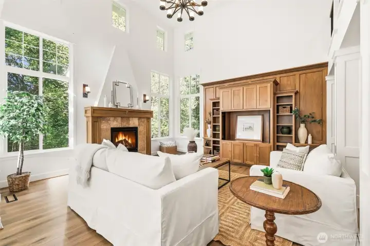 Beautiful formal living room with soaring ceilings, tons of natural light, gleaming new floors and cozy fireplace.