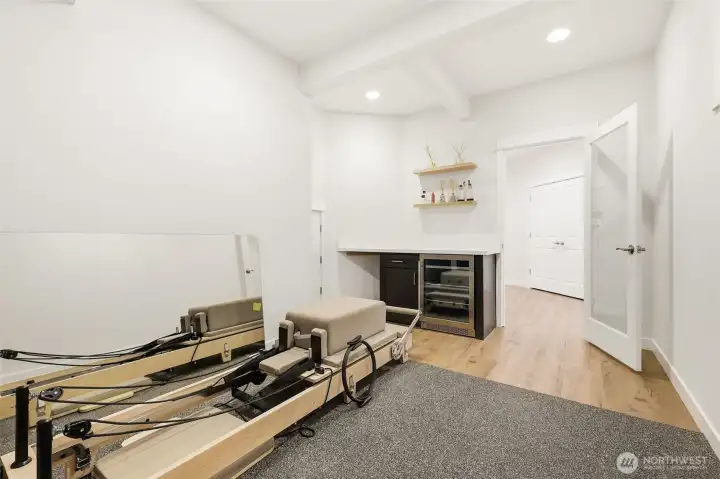 Lower-level gym with increased lighting, window and built-in drink station and storage.