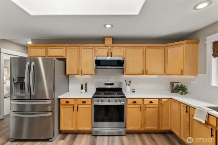 Updated kitchen with quartz counters, walk in pantry, stainless appliances, and new tile backsplash Updated kitchen with quartz counters, walk in pantry, stainless appliances, and new tile backsplash