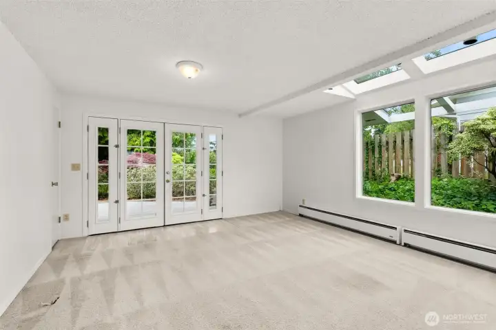 Great room with plenty of natural light and French doors leading to spacious deck Great room with plenty of natural light and French doors leading to spacious deck