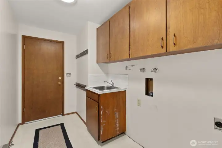 Laundry with sink and door leading into the garage. Laundry with sink and door leading into the garage.