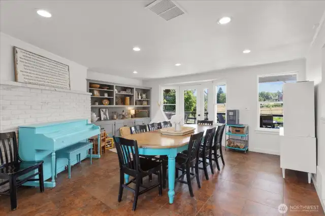 Extra-large dining room off kitchen with access to covered deck, built-ins and recessed lighting.