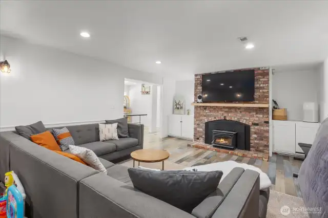 Spacious lower-level family room with brick fireplace, recessed lighting and built-ins for added storage!