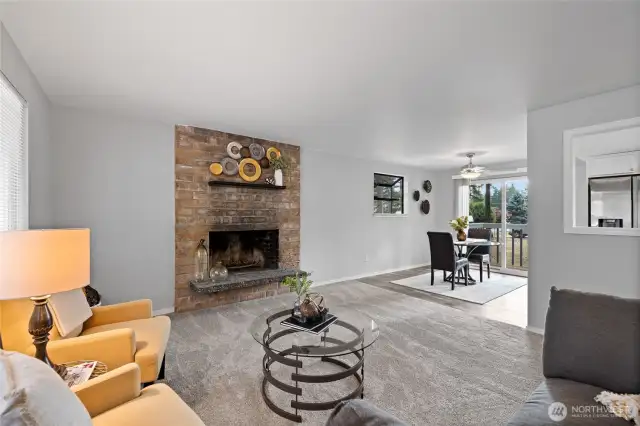 View of living room into the the adjoining dining area. Notice the window/cutout into the kitchen.