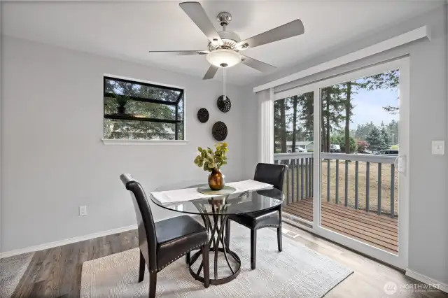 Dining area with ceiling fan and garden window.
