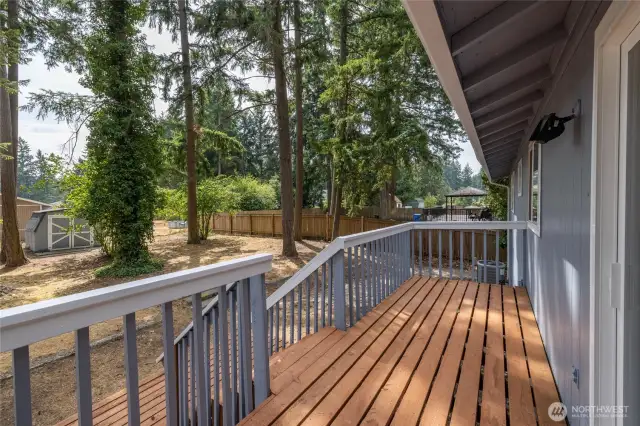 Refreshed deck that leads to large backyard - garden shed beyond.