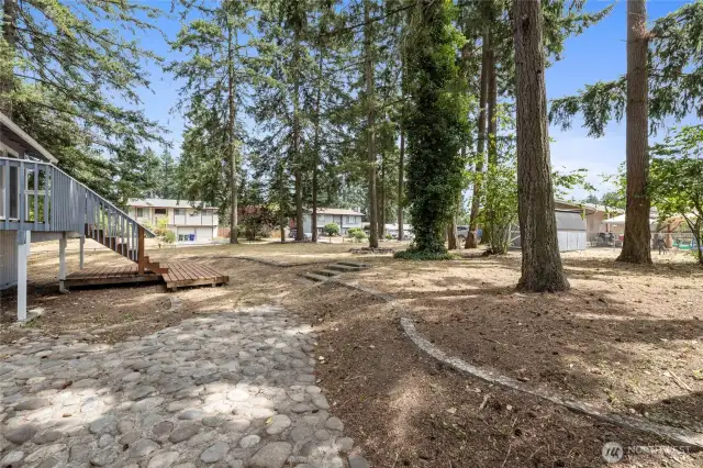 The stone patio area offers some dimension to this spacious backyard.