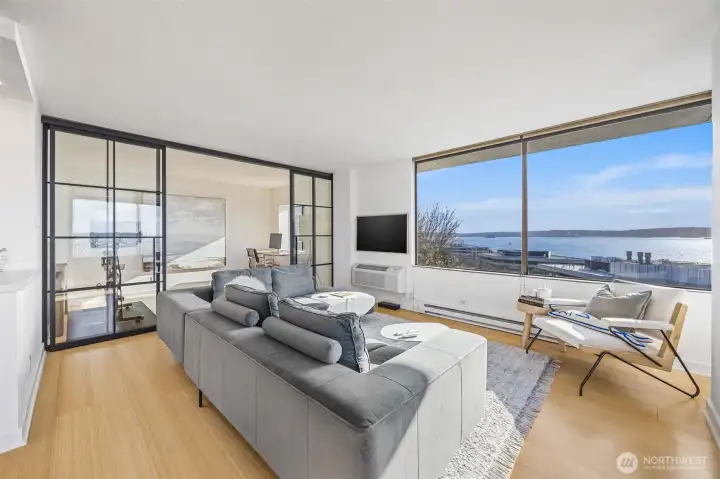 Custom steel and glass partition adds an artful design to the sprawling living area and provides a beautiful separation of space.