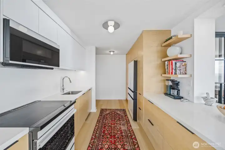 Kitchen lighting by American designer, Kelly Wearstler, provides an artful play and adds to the minimalist, modern finishes.