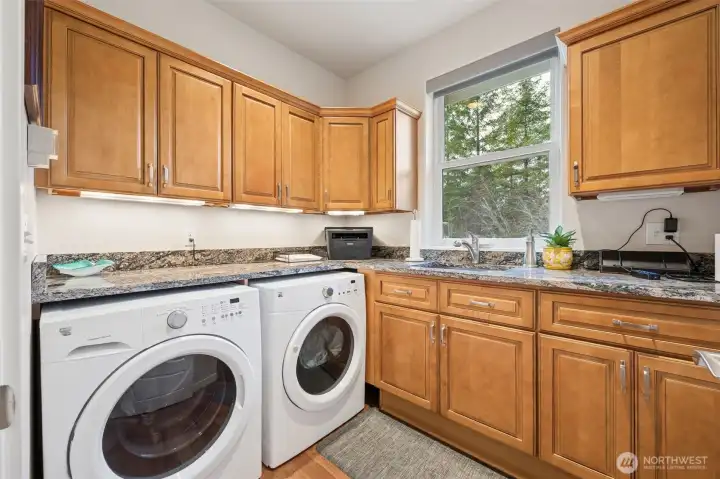 Big utility room with sink, quartz countertops and plenty of cabinets. Washer and Dryer to stay.